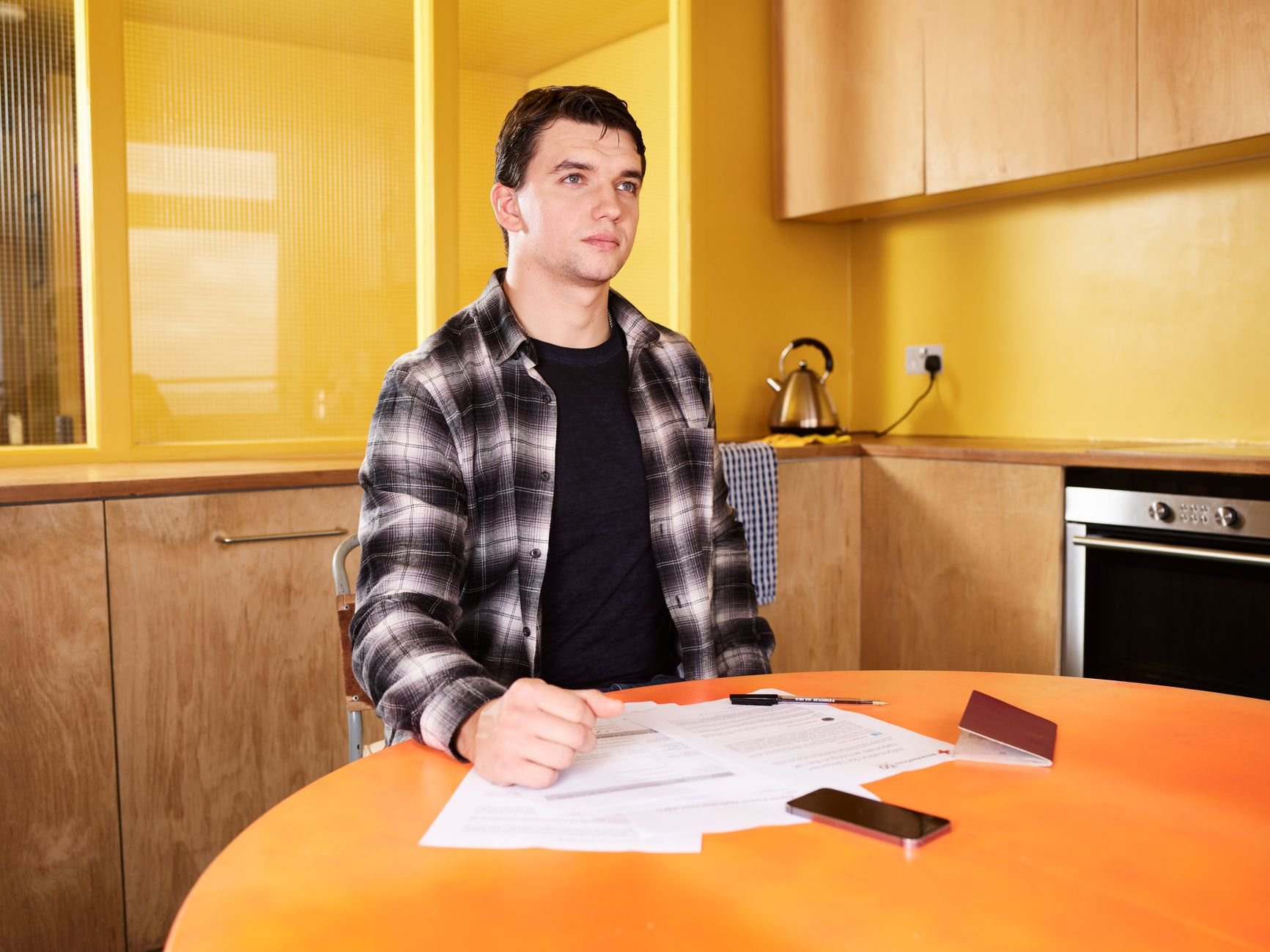 Man sitting at kitchen table reviewing documents with focus — understanding his case at last